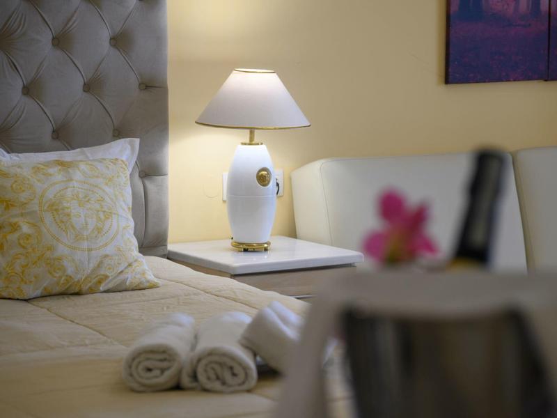 Camera d'albergo accogliente con cuscini comodi, lampada da comodino e asciugamani appena arrotolati.