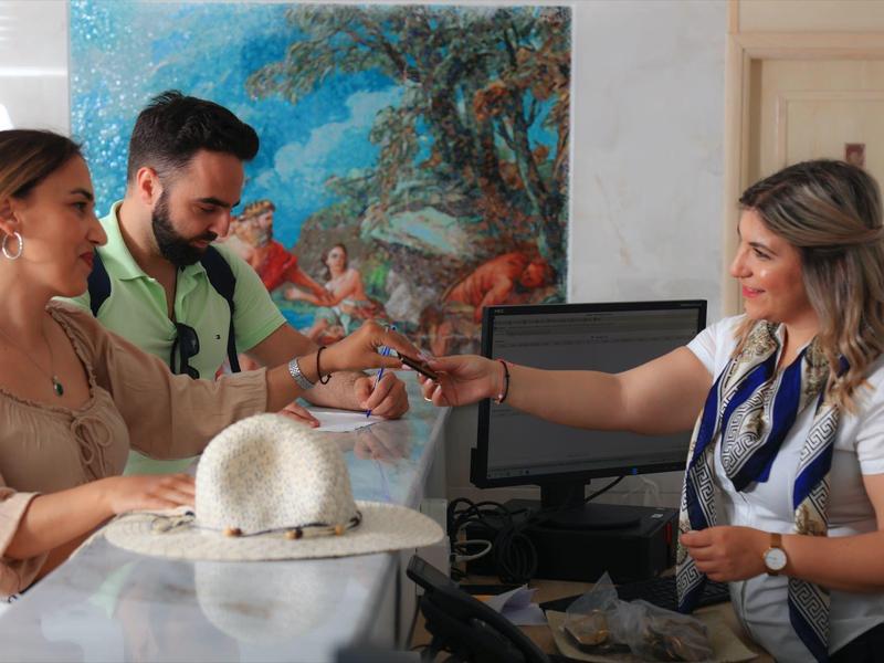 Coppia al check-in alla reception dell'hotel con una receptionist cordiale.