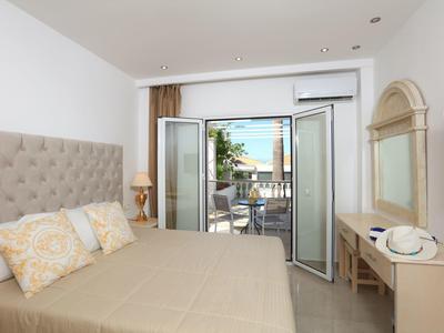 Helles Schlafzimmer mit großem Bett, Balkon mit Meerblick und heller, moderner Einrichtung.