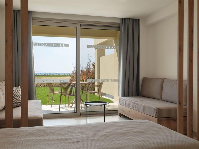 Modernes Schlafzimmer mit Bett, Sofa, Glas-Schiebetür und Balkon mit Gartenblick.