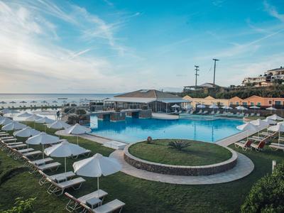 Piscina con lettini e ombrelloni sulla costa al tramonto