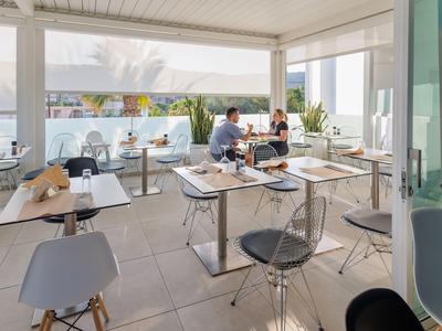 Café moderne et lumineux avec de grandes fenêtres et vue sur la mer.