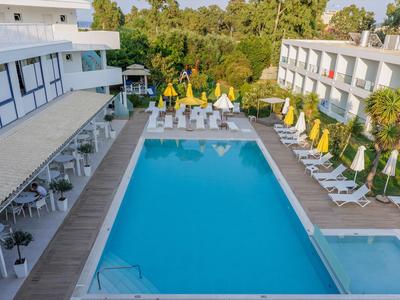 Modern outdoor pool between two buildings with umbrellas and lounge chairs
