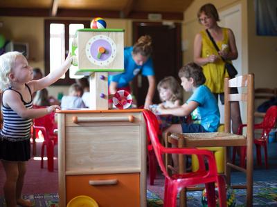 Kindergartenkinder spielen im Klassenraum mit buntem Spielzeug und bunten Möbeln.