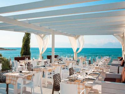 Terrasse avec tables dressées donnant sur la mer par temps clair