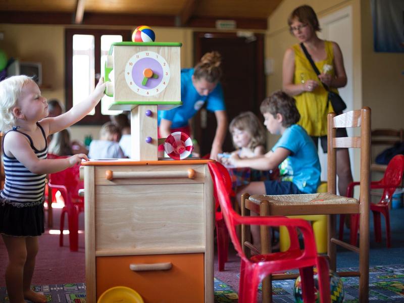 Kindergartenkinder spielen im Klassenraum mit buntem Spielzeug und bunten Möbeln.