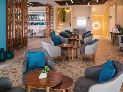 Moderne Hotellounge mit bequemen Sesseln und dekorativen Holzelementen.