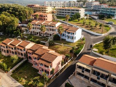 Luftaufnahme einer Wohnanlage mit mehrstöckigen Gebäuden, roten Dächern und grünen Bäumen.