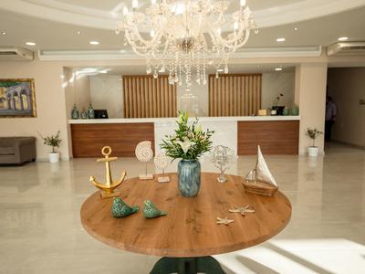 Eleganter Empfangsbereich mit rundem Holztisch, Blumen, Dekorationen und Kronleuchter.