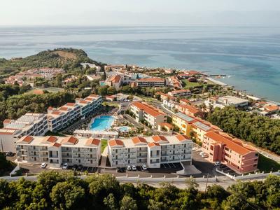 Luftaufnahme eines weitläufigen Strandresorts mit Pool und Blick auf das Meer.