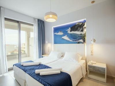 Modern bedroom with double bed, blue bed cover, and large wall picture