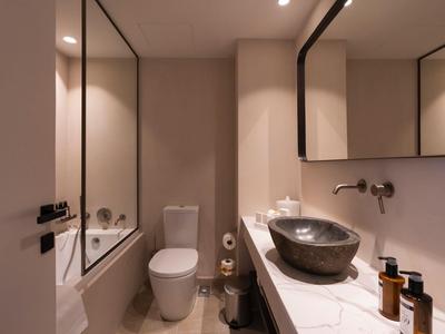 Bagno moderno con WC, grande specchio e lavabo nero su piano bianco