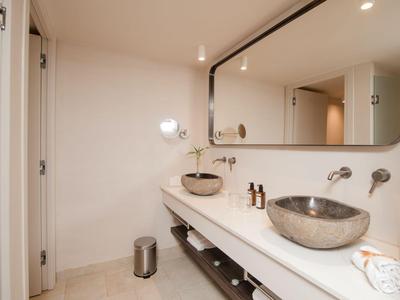 Modernes Badezimmer mit Doppelwaschbecken, großem Spiegel und neutralen Farben.