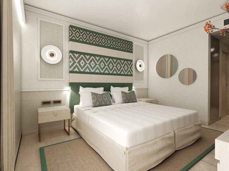 Modern eingerichtetes Schlafzimmer mit großem Doppelbett, gemustertem Wandteppich und runden Spiegeln.