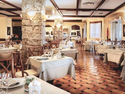 Cozy restaurant with wooden furniture, stone pillars, and warm lighting.