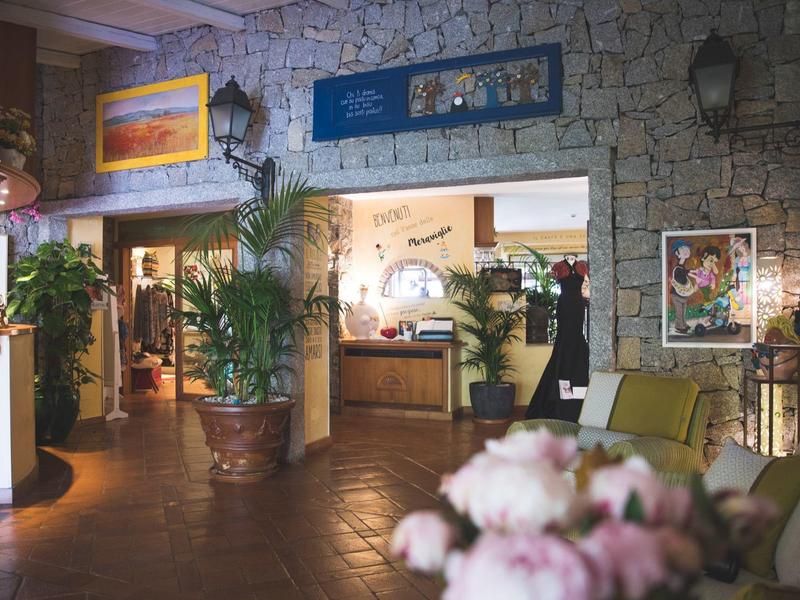Cozy hotel lobby with stone walls, plants, and floral arrangements
