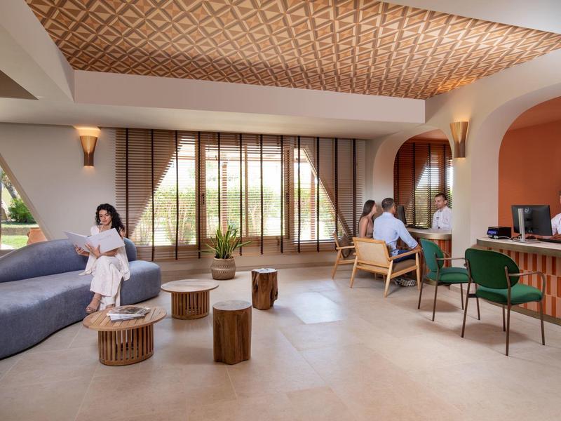 Moderne hotel lobby met gezellige zitplekken, houten accenten en natuurlijk licht.