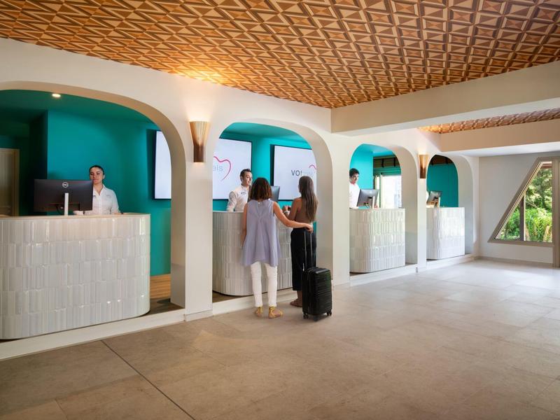 Moderne receptieruimte met balies en twee staande personen in een elegante omgeving.