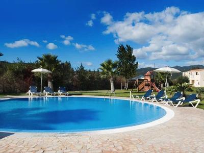 Duży basen z leżakami i tropikalnym krajobrazem pod czystym niebem