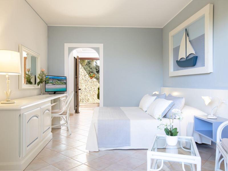 Helles, modernes Schlafzimmer mit Doppelbett, maritimer Deko und Blick auf Außenbereich durch Tür.