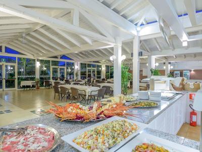 Buffet mit verschiedenen Speisen in einem hellen, offenen Restaurant mit weißen Holzbalken.