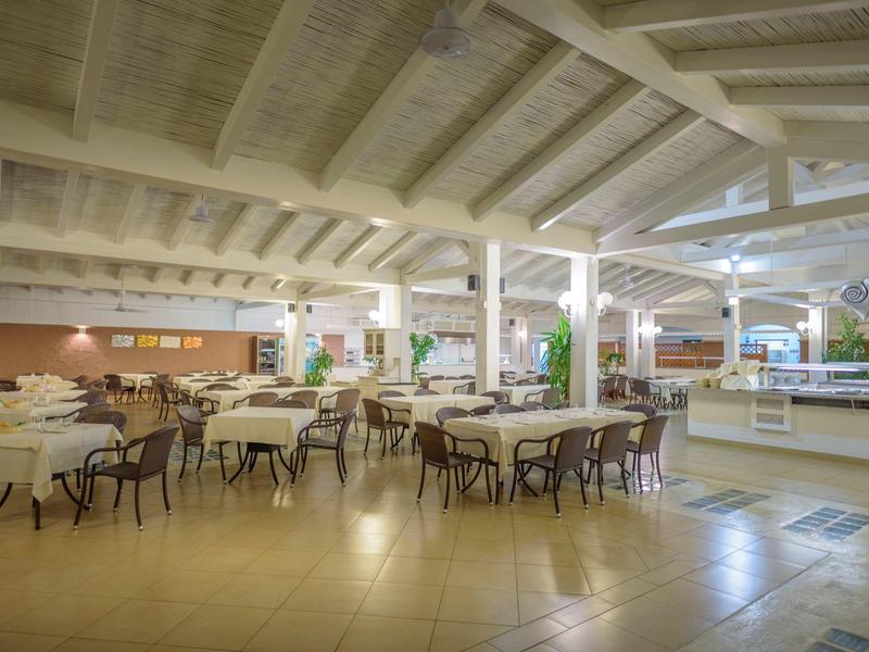 Großer heller Speisesaal mit gedeckten Tischen und Stühlen in einem Hotel.