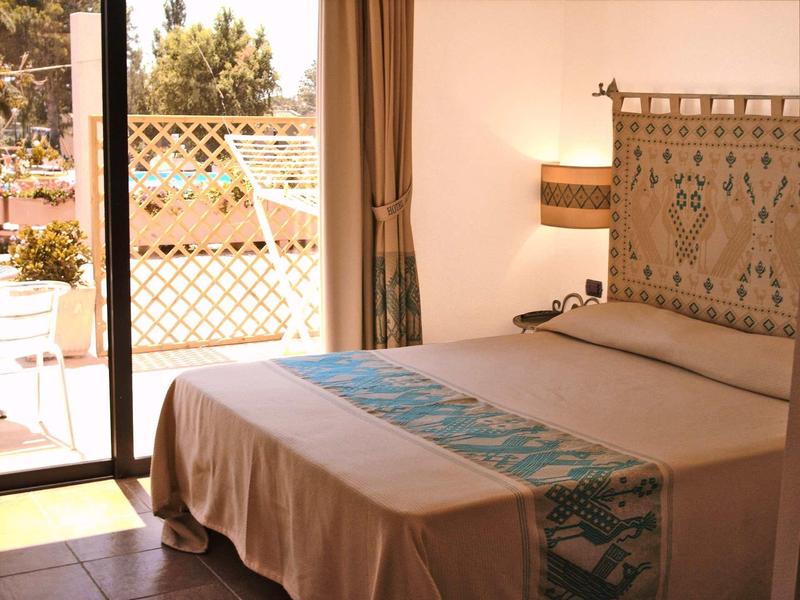 Chambre confortable avec lit double et accès au balcon dans une chambre d'hôtel.