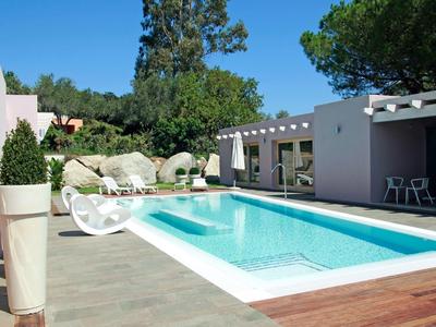 Nowoczesny basen na zewnątrz z leżakami i pergolą pod czystym niebem.