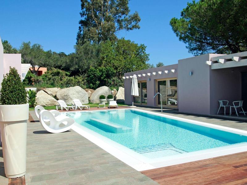 Nowoczesny basen na zewnątrz z leżakami i pergolą pod czystym niebem.