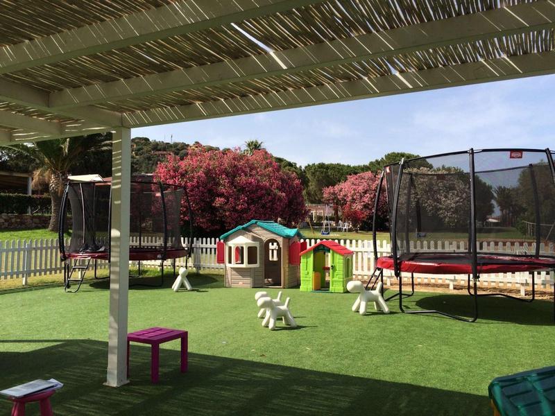 Plac zabaw z kolorowymi domkami i trampolinami pod zadaszeniem w hotelu.