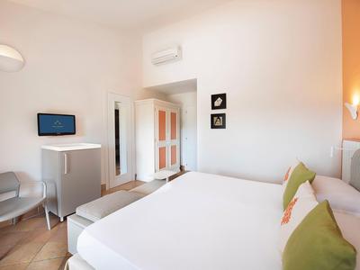 Chambre d'hôtel moderne avec grand lit, climatisation et décoration minimaliste.