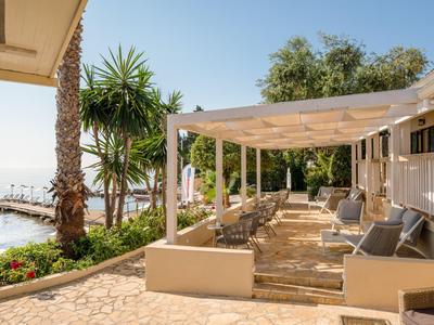 Terrasse eines Hotels mit Sitzbereich und Meerblick unter klarem Himmel.