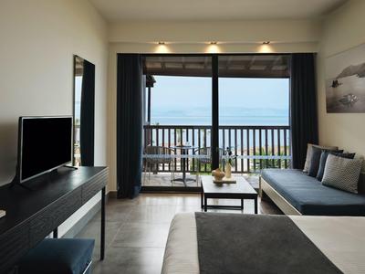 Modern eingerichtetes Hotelzimmer mit Balkon und Meerblick.