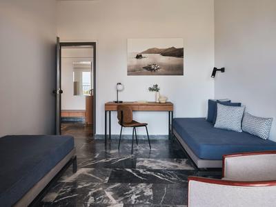 Modernes Wohnzimmer mit blauen Sofas, Schreibtisch, Stuhl und Marmorfliesenboden.