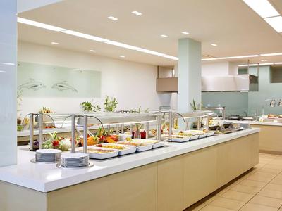 Buffet mit warmen und kalten Speisen in modernem, hellen und gut beleuchtetem Raum.