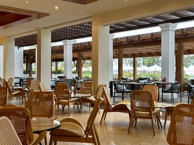 Helles Restaurant mit Holzstühlen und großen Fenstern für Außenblick.