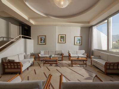 Helles, modernes Wohnzimmer mit Sitzgruppen und großen Fenstern mit Bergblick.