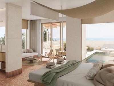 Helles Hotelzimmer mit großem Bett, Sitzbereich und Meerblick, modern und gemütlich gestaltet.