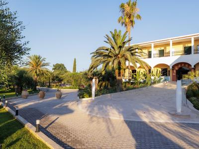 Edificio del hotel con una veranda y palmeras alrededor bajo un cielo despejado