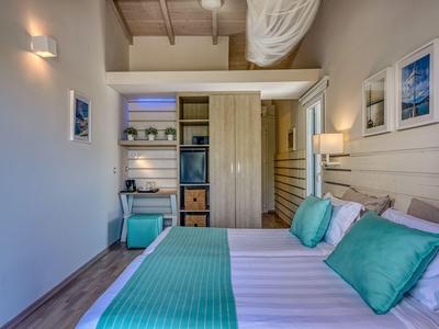 Modern eingerichtetes Hotelzimmer mit Doppelbett und türkisfarbenen Akzenten.
