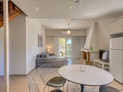 Moderner Wohnbereich mit Esszimmer, Sofa, Kamin und großem Fenster mit Blick nach draußen.