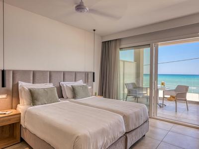 Modernes Hotelzimmer mit zwei Einzelbetten und Meerblick von Balkon aus.
