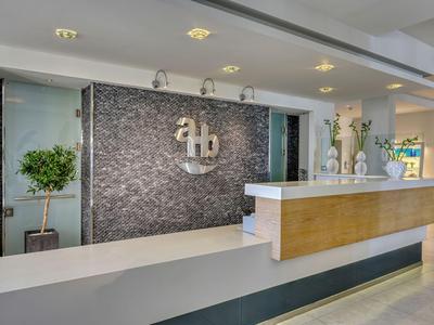 Moderner Hotel-Empfang mit glänzender Rezeptionsfläche und dekorativem Hintergrund.