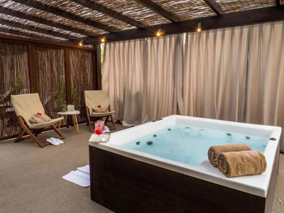 Wellnessbereich mit Whirlpool, Liegestühlen und gedämpfter Beleuchtung in einem Hotel.