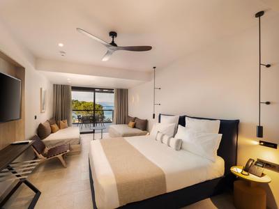 Modern eingerichtetes Hotelzimmer mit großem Bett, Balkon und Seeblick.