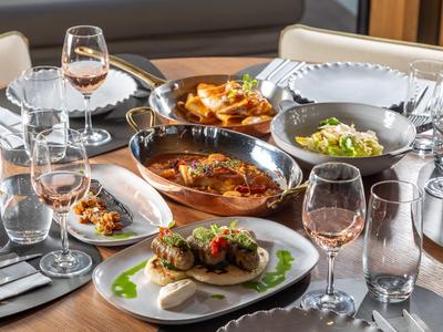 Tisch mit verschiedenen Speisen und Gläsern in einem Restaurant mit elegantem Ambiente