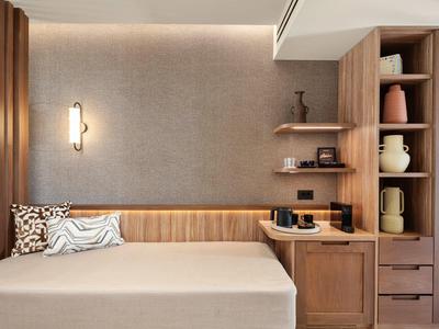 Modern eingerichteter Raum mit Bett, Holzregalen und stilvoller Beleuchtung