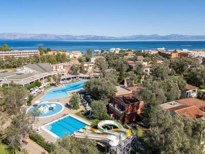 Hotelanlage mit mehreren Pools, Wasserrutschen und Blick auf das Meer im Hintergrund.