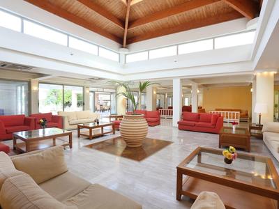 Großer Hotel-Loungebereich mit bequemen Sofas, Sesseln und Holzdecken mit Fenstern an der Decke