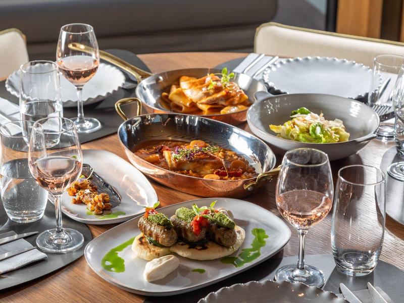 Tisch mit verschiedenen Speisen und Gläsern in einem Restaurant mit elegantem Ambiente